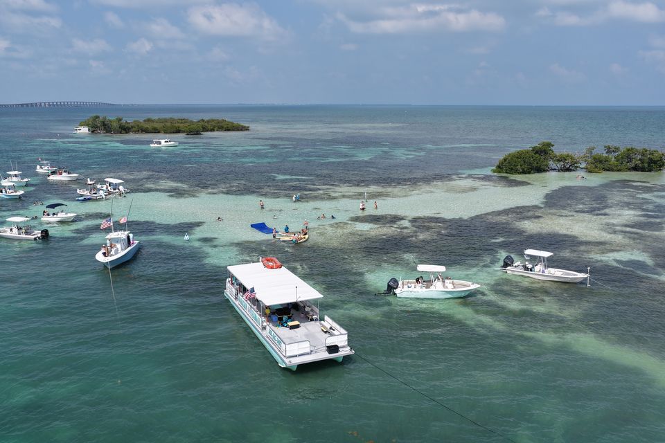 Aerial view of the Marathon Mermaid anchored at the turquoise sandbar with the Seven Mile Bridge behind
