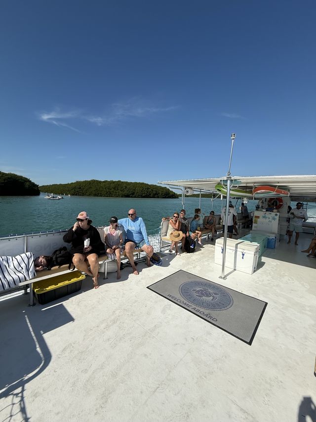 Guests seated under the shade canopy with the company logo mat on the deck