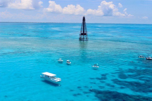 a blue and white boat sitting next to a body of water