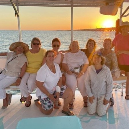 a group of people sitting in front of a body of water