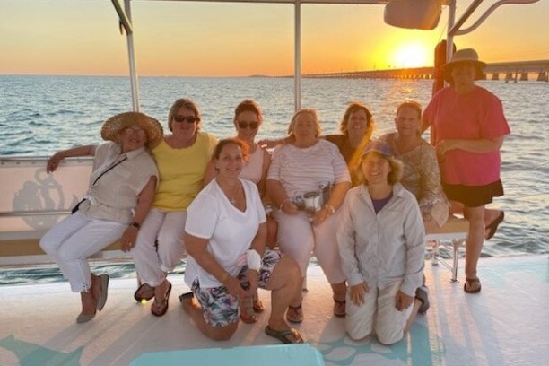a group of people sitting in front of a body of water