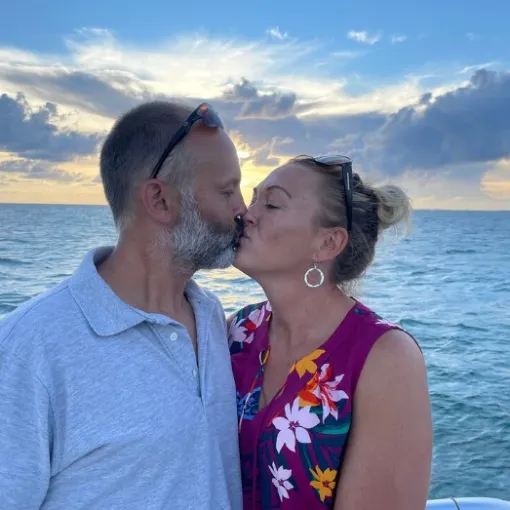 a man and a woman standing in front of a body of water